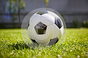 Football of soccer game lying on the grass of the garden