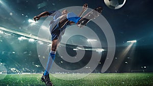 Football or soccer player in action on stadium with flashlights, kicking ball for winning goal, wide angle. Action