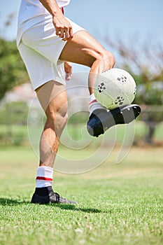 Football, soccer player and balance ball on foot on a grass field, sports pitch and a park ground. Man training for