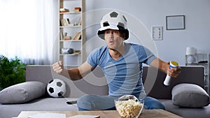 Football supporter in fan hat waiting for decisive penalty kick, championship