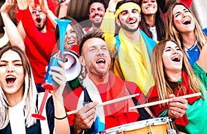 Football supporter fans cheering with drums watching soccer cup match at stadium bleachers