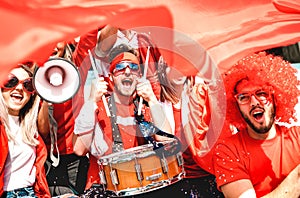 Football supporter fans cheering with flag watching soccer cup match at stadium tribune