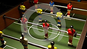 football on the table at night the light blinks goal, toy red white, EUR face. Competitive taca figurine table soccer