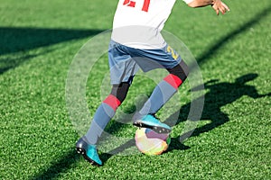 Football teams - boys in red, blue, white sportswear play soccer on the green field. boys dribbling. dribbling skills. Team game,