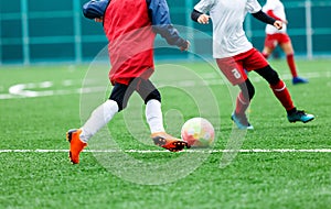 Football teams - boys in red, blue, white uniform play soccer on the green field. boys dribbling. dribbling skills. Team game