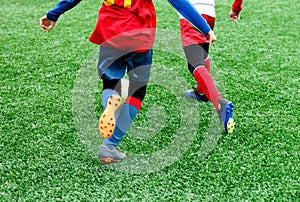 Football teams - boys in red, blue, white uniform play soccer on the green field. boys dribbling. Team game, training, active life