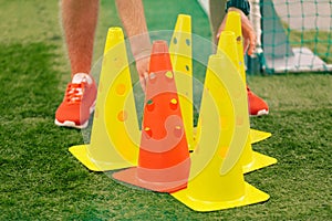 Football Training Cones. Coach Preparing Practice Soccer Field With Red and Yellow Training Cones