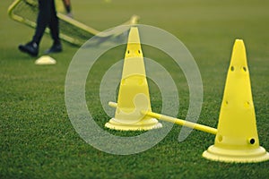 Football Training Equipment. Yellow Soccer Cones on Grass Pitch