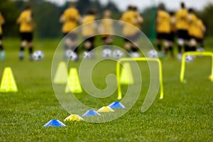 Football Training Session. Soccer Balls, Pylons, Cones, Marks and Training Hurdles on Grass Pitch