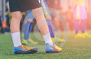 footballer feet closed up on a green grass field for youth soccer training concept