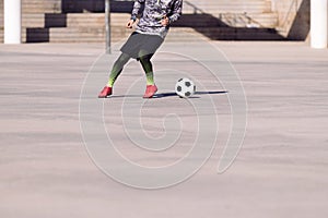 Footballer playing the ball in a concrete court