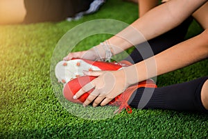 Footballer is sitting and catch the ankle of the feet because of pain, soccer player was injured in the foot