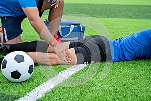 Footballer wearing a blue shirt, black pants injured