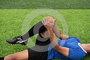Footballer wearing a blue shirt, black pants injured
