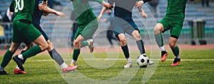 Footballers in action on the tournament game. Soccer football players competing for ball and kick ball during match in the stadium