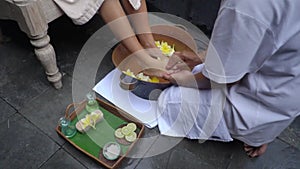 Footbath to client, beautician polish girl`s toes with slice of lemon for health
