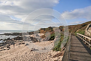 Footbridge along the beach rises to the top of the cliff photo