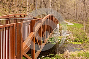 A Footbridge On A Hiking Trail Crossing A Creek During Spring