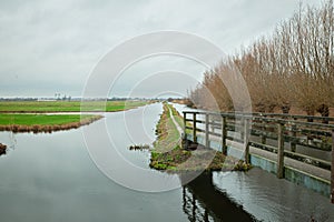 Footbridge leading to a polder landscape in Holland