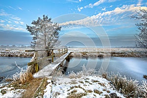 Footbridge over Frozen canal in the province of Drenthe