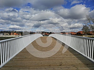 Footbridge over river and buildings in the background photo