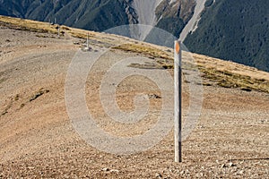 Footpath across scree slope with poles marking way