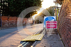 `Footpath Closed` sign and a temporary wheelchair ramp informing the public of the closure ahead
