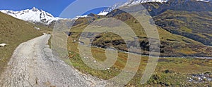 Footpath corssing alpine mountain with glacier background