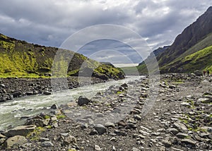 Footpath at Laugara river valley to Seljavallalaug abandoned theramal swimming pool in South Iceland, green hillos and