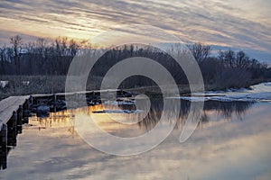 Footpath over a lake at sunset surrounded by woods