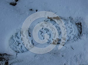 Footprint of male footwear on white snow