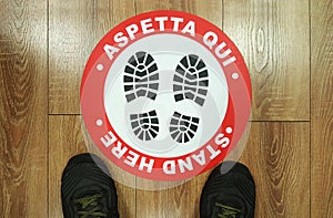 Footprint sign red color with text aspetta qui