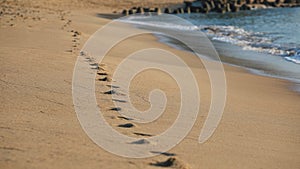 Footprints a barefoot runner on beach. Barefoot trail, step track on sand texture. Bare human feet on wet sand.