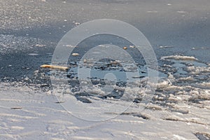 Footprints on a frozen lake with snow surface and thin ice