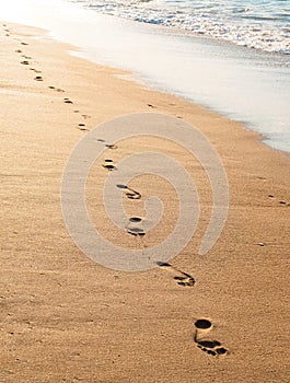 footprints on the golden sand by the sea