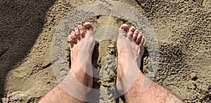 Footprints of human feet on the warm sand photo