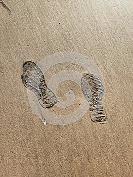 Footprints of human on wet sand. Beach sand seamless background.