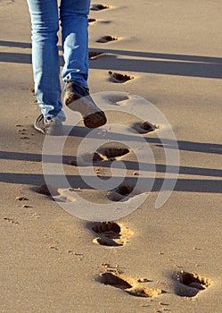 Footprints left in the wet sand by a group walking on the beach.