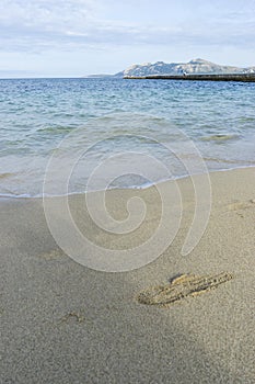 Footprints in the sand of a beach by the Mediterranean sea on th