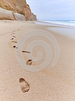 Footprints on the sand of the beach on overcast day