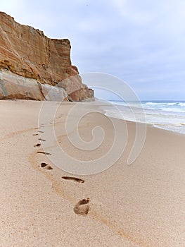 Footprints on the sand of the beach on overcast day