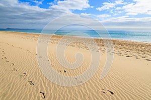 Footprints in sand on and beautiful turquoise sea on Jandia beach, Morro Jable, Fuerteventura, Canary Islands, Spain