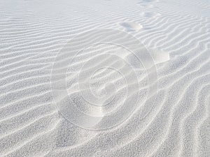 Footprints on sand dune. White sand closeup