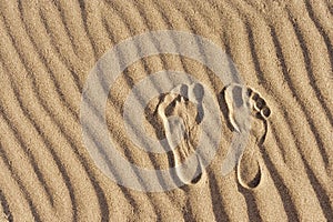 Footprints in the sand. Imprint of man`s foot on the sand on the beach