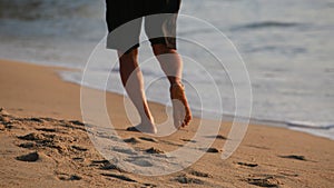 Footprints in sand left by a barefoot runner on beach.