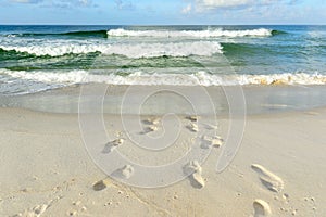 Footprints in sand on a sea beach in the morning