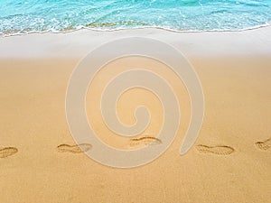 Footprints in sand on sea coast.