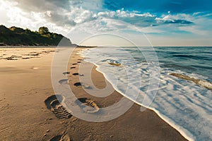 Footprints on sandy beach being washed away, transient imprints