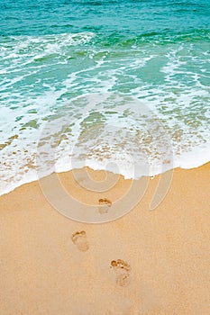 Footprints in the sea sandy beach , wave foam on a vacation tim