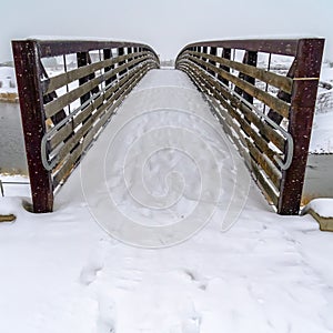 Footprints on snow covered bridge in Daybreak